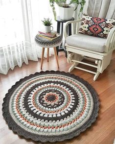 a crocheted rug is shown on the floor next to a chair and table