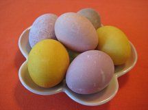 four eggs in a white bowl on an orange table