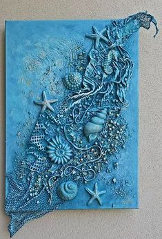 a blue painting with shells and starfishs on the bottom is hanging on a wall