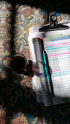 a clipboard with some writing on it next to a cup of coffee