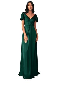 a woman in a long green dress standing with her hands on her hips and looking off to the side