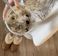 a woman is holding a bowl of food