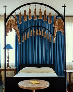 a canopy bed with tassels hanging from it's sides in a bedroom