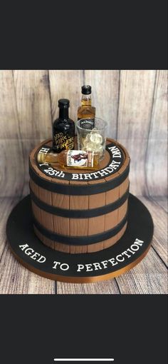 a birthday cake made to look like a barrel with liquor bottles on the top and bottom