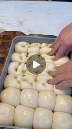 someone is placing doughnuts into a pan