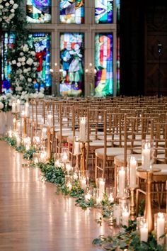 the aisle is lined with candles and greenery