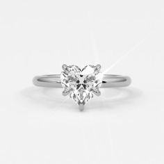 a heart shaped diamond ring on a white background