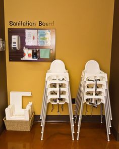 two white chairs sitting next to each other in front of a sign that says sanitition booth