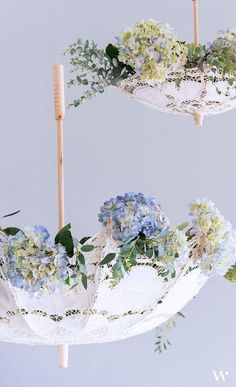 two umbrellas that have flowers in them hanging from the ceiling and one is upside down