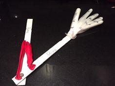 a pair of white gloves sitting on top of a piece of paper with red handles