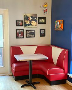 the corner booth is red and white with black accents, along with pictures on the wall