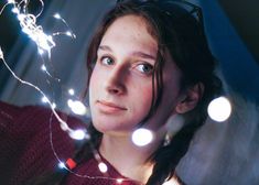 a young woman is looking up at the camera with lights in her hair and eyes