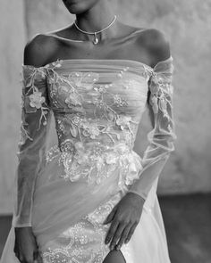 black and white photograph of a woman in an off the shoulder dress with flowers on it