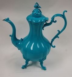 a blue glass teapot sitting on top of a table