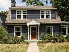 a blue house with white trim and windows on the front door is shown in this photo