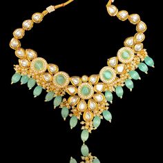 Variations:- Mint Pink Emerald The Teal Aayra Kundan Neckline Set features a beautiful combination of high quality Kundan, American Diamond, Teal Beads and Pearls. Set comes with a necklace and a pair of earrings. The center of the necklace has a beautiful flower motif with teal monalisa beads in the center, surrounded by american diamonds. The flower petals are made of beautiful kundan. The back of the necklace and earrings have hand painted meenakari which gives a smooth fit. Key Features:Mate Festival Necklaces With Latkans For Receptions, Latkans Necklaces For Diwali Reception, Latkans Necklace For Diwali Reception, Diwali Reception Necklace With Latkans, Festive Necklaces With Latkans For Receptions, Festive Bridal Necklace With Dangling Beads, Festive Latkans Necklace For Reception, Kundan Bridal Necklace With Dangling Beads For Festivals, Bridal Kundan Necklace With Dangling Beads For Festivals