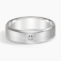 a white gold wedding band with a diamond in the center and a beveled edge