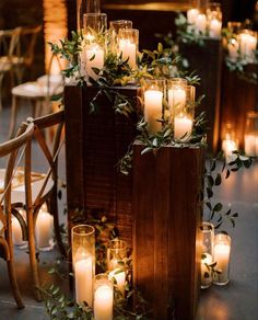 candles and greenery are arranged on the back of an old wooden box for a centerpiece