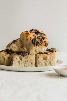 pieces of bread sitting on top of a white plate next to a small saucer