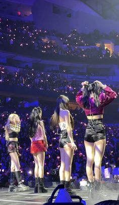 the girls are standing on stage with their backs turned to the audience and one is wearing short shorts