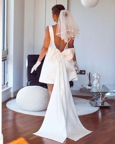 a woman in a wedding dress is standing on the floor with her back to the camera