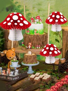 a table topped with lots of cakes covered in red and white frosted toppings