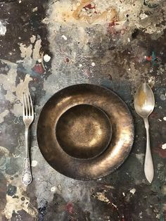 an empty plate and silverware on a dirty surface