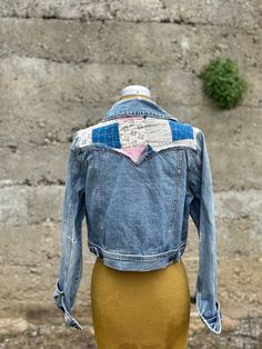 a mannequin wearing a jean jacket with patches on it's chest and back