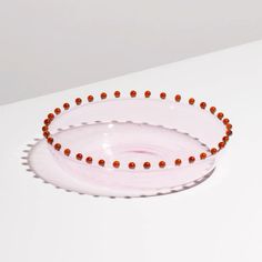 two white bowls with red beads on them