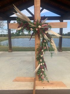 a cross decorated with flowers and greenery