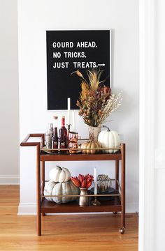 there is a table with some drinks on it, and a sign that says gourd ahead no tricks just treats