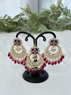 Kundan jewelry set includes a pair of earrings and a tikka. Colour: red Red Ruby Chandbalis For Diwali, Elegant Red Ruby Jhumkas, Heavy Ruby Chandbalis As Gift, Red Tikka With Tilla As Gift, Heavy Red Ruby Chandbalis, Red Hand Set Chandbali Jhumkas, Heavy Ruby Red Chandbalis, Bollywood Style Red Ruby Earrings, Heavy Ruby Chandbalis For Gift