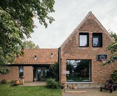 a brick house with two large windows and a basketball hoop