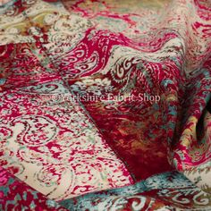 an image of a red and blue fabric with paisley designs on it's sides