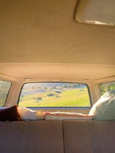 two people are sleeping in the back of a van with their feet on the bed