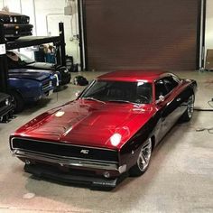 a red muscle car parked in a garage