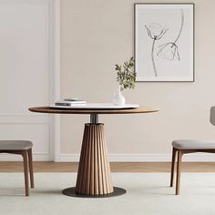 a dining room table with two chairs and a vase on the table in front of it