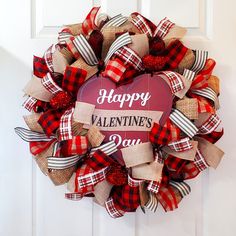 a happy valentine's day wreath hanging on a door with burlocks and ribbon