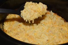 a spoon full of macaroni and cheese being scooped from the crock pot