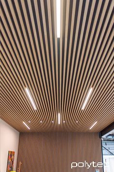 the ceiling is made out of wood and has vertical lines on it, making it appear to be suspended