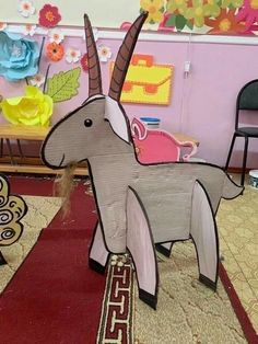 an animal made out of cardboard sitting on top of a rug