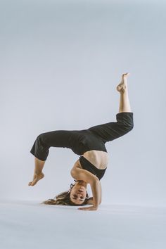 a woman is doing a handstand on one leg