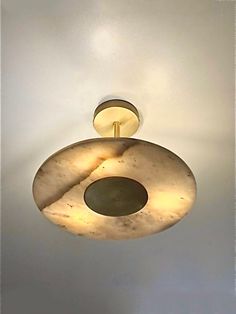 two circular lights hanging from the ceiling in a room with white walls and flooring