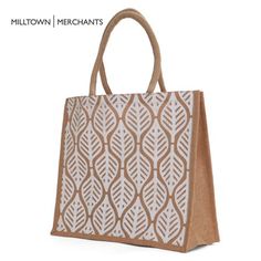 a brown and white bag with an intricate design on the front, sitting against a white background