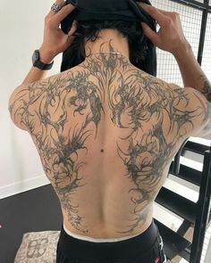 the back of a man with tattoos on his body