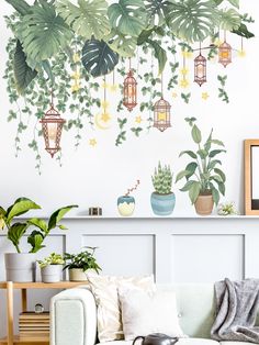 a living room filled with lots of green plants and potted plants on the wall