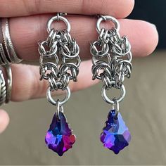 Handmade Maille & Dark Purple Blue Pink Iridescent Rainbow Austrian Crystal Dangly Earrings . Earrings Posts Are Stainless Steel . To Create The Maille Links I Use Stainless Steel Hoops As Well . It Is Nickel Free , Allergy Free , Hypoallergenic , No Itching , Do Not Change Color , Rust Or Turn Skin Green . Handmade By Me Any Questions Lmk ! Handcrafted / Boho / Bohemian / Boho Chic / Gypsie / Hippie / Festival / Goth / Gothic / Viking / Medieval / Victorian / Rock & Roll / Rocker / Rock Chic / Purple Dangle Crystal Earrings, Adjustable Purple Dangle Crystal Earrings, Gothic Viking, Whimsical Nickel-free Purple Earrings, Nickel-free Purple Dangle Chandelier Earrings, Viking Medieval, Spiked Jewelry, Purple Multi-stone Dangle Jewelry, Purple Rainbow