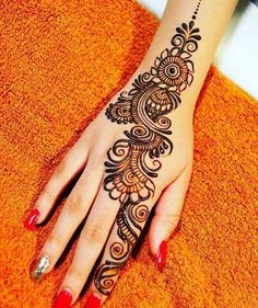 a woman's hand with henna tattoos on it