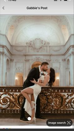 a man and woman are kissing in front of a balcony with ornate railings on either side