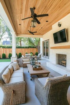 an outdoor living area with wicker furniture and a ceiling fan on the side of it